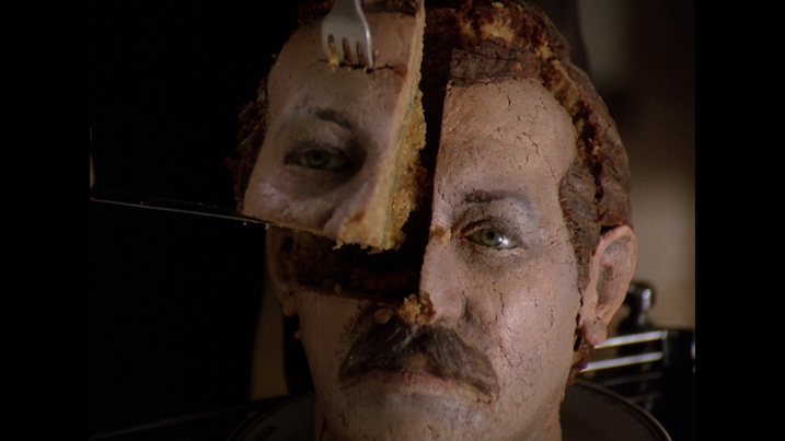 Zerograd’s surreal cake-cutting sequence, where a head-shaped cake is served (Promotional use, not captured from Blu-ray)