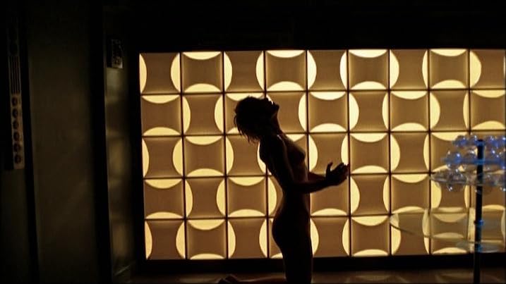  Promotional image from In the Dust of the Stars showing a woman in silhouette kneeling dramatically before a glowing retro-futuristic wall panel, evoking 1970s space disco vibes.
