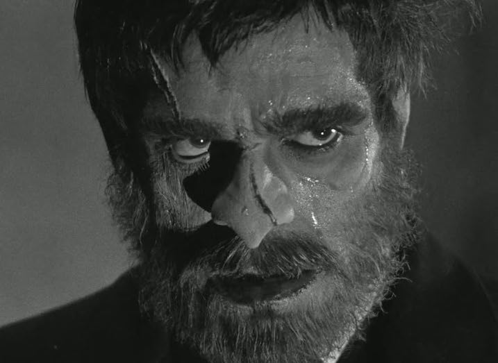  Terrifying close-up of Boris Karloff as the brutish Morgan in The Old Dark House (1932), drenched in sweat with wild eyes and a prominent scar—highlighting the film’s monster movie legacy.