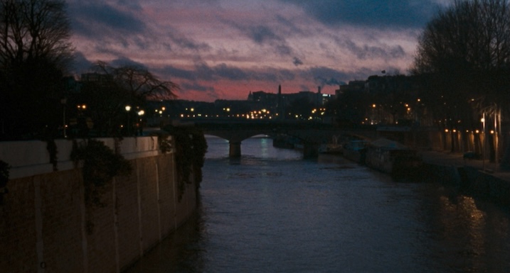 Paris bridge over the Seine at dusk from Trouble Every Day, with streetlights and a purple-blue sky.