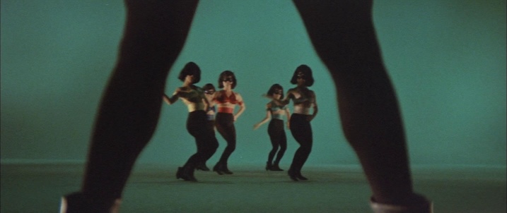 Dance sequence still: “Scene from Black Tight Killers (1966) with go-go dancers framed between silhouetted legs, capturing the film’s playful pop-art style.”
