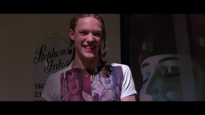 Matthew Lillard in Hackers (1995) – smiling in close-up, wearing a T-shirt with graphic art print.