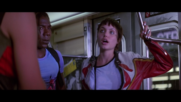 Angelina Jolie as Kate Libby in Hackers (1995) – subway scene with Jolie wearing a red and white leather jacket.