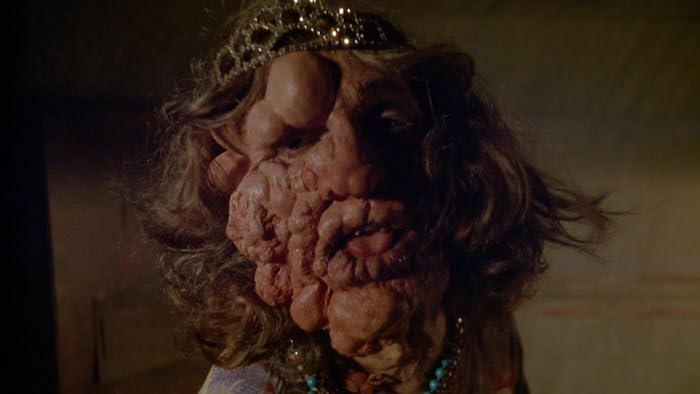Mutated creature with distorted face wearing tiara in Shadowzone movie still.