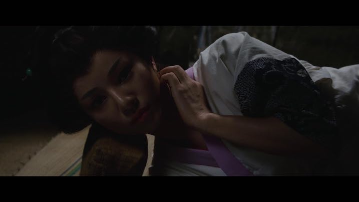 Miyoko Akaza as Otsuyu reclining in The Bride from Hades – wearing traditional kimono, softly lit against a dark room.